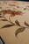 Modern Chinese hand-knotted rug angled view, large leaves and open beige ground showing silk sheen