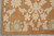 Corner of the 9x13 wool rug with plain goldish brown margin framing ivory blossoms