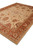 Side angle of the wool rug showing coral guard borders and pale ivory outer stripe