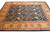 Camel gold and rust border framing the navy trellis field of this large transitional wool rug