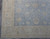 Corner detail showing ivory main border, brown accents, blue guard stripes and tight selvedge edge