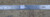 Ruler laid across the ivory border measuring knot density, authentic handmade verification label visible