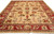 Angled 10x14 Peshawar Oriental rug showing all-over floral field and wide red main border