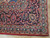 Corner detail showing navy main border, blue guard stripes and ivory floral vine scrollwork