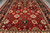 Tomato red field covered with multicolored rosettes and vine scrolls between two deep navy side borders
