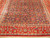 Angled floor view showing brick red main border, ivory guard stripes and repeating lattice panels