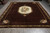 10'2 x 14 hand-knotted Indian rug showing full brown field, corner sprays and ivory fringe