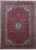 Deep red Persian Kashan rug with navy lobed medallion and ivory cornerpieces, full overhead view
