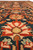 Field close-up of rust and peach lotus palmettes blooming across the deep teal ground