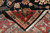 Folded corner revealing tight weave on the back and ivory fringe of this Serapi design rug