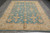 Angled overhead shot of 9x12 Peshawar Zigler rug with cream border and blue field
