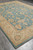 Corner perspective showing ivory border flowers, aqua field and low quarter-inch natural wool pile