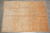 Warm taupe and rust hand-knotted wool rug photographed flat on a grey tile showroom floor