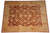 9x12 Chobi Peshawar rug viewed from above, soft gold border framing deep rust field