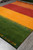 9' x 12' multicolor striped wool rug angled across grey tile floor in our showroom
