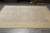 Ivory border and grey field of this 9x12 Pakistani wool rug viewed lengthwise from one end