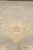 Close detail of a gold palmette with small rust crown rising from the grey field