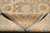 Folded corner revealing tight cotton foundation weave behind the gold and cream floral border
