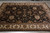 Hand-knotted wool rug from India photographed on grey tile, black field and cream floral border