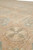 Low angle detail of low pile wool surface with beaded roundel and peach accents
