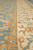 Border close-up with gold guard stripe dividing blue field from ivory floral main band