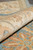 Rolled edge revealing dense natural wool pile, ivory border drawing and blue wool selvage