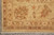 Corner detail of the 8 by 10 rug with brown palmette, red outlines and hand-tied fringe