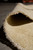 Rolled corner close up showing quarter inch natural wool pile and ivory cotton fringe