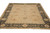 Angled floor view showing camel field and charcoal black border of hand-knotted wool rug