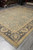 Hand-knotted Chobi rug displayed in our warehouse beside stacked Oriental rugs, cream fringe in the foreground