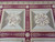 Two square panels with cream rosette medallions on olive and sage quartered needlepoint grounds