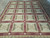 8 x 10.1 needlepoint rug seen from above with olive, beige and burgundy panel grid