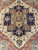 Close-up of navy stepped medallion with coral panels, sage cruciform center and ivory field