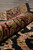 Rolled edge view showing lustrous dense wool pile across burgundy, ivory and black border bands