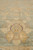 Close-up of gold palmette motif with fine red outline woven into muted green wool field
