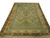 Studio view of green Turkish Oushak rug with rust and blue lattice on white background