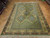 9x11 Turkish Oushak rug seen from above, green field, rust palmettes and ivory guard borders
