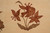 Close-up of spotted lily spray outlined in oxblood red with olive silk leaves