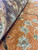 Pile thickness shown with rug rolled back, revealing natural wool luster in rust and brown