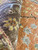 Macro view of hand-spun wool knots forming blue starflowers on the rust ground, Agra weave