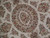 Close-up of oval medallion with cabbage roses, scrolling vines and ivory ground in fine wool