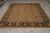Full overhead view of hand-knotted Oriental rug with ivory fringe, black floral border, olive field