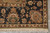 Corner detail with cream guard band, fringe and black ground florals in sage and rust tones