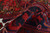 Folded pile showing thick vintage wool, cherry red tones and dark navy geometric drawing