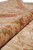 Rolled edge view showing plush natural wool pile depth in gold, brown and red tones