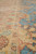 Border detail showing brown outlines, red accents and turquoise vines woven in natural wool