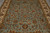 Close angled view of light blue field covered in brown, gold and rust floral motifs