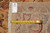 Back of rug with tape measure and handwritten tag confirming hand woven Oriental origin