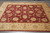8'2 x 9'8 hand-knotted wool rug photographed at an angle on grey tile showroom flooring