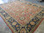 Angled floor view showing coral field, sage guard stripes and ivory cotton fringe ends